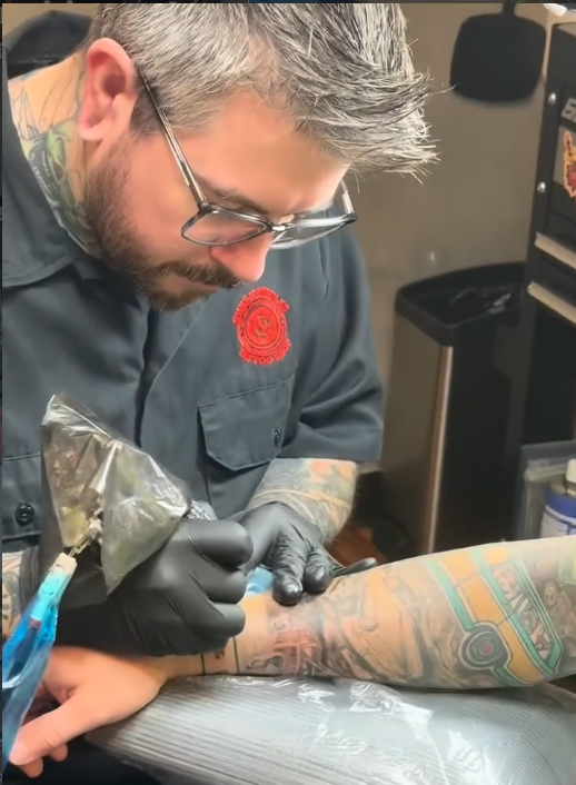 Travis tattooing a client
